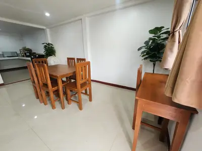 a dining room with a wooden table and chairs at Sabai - Sabai in Bangkok