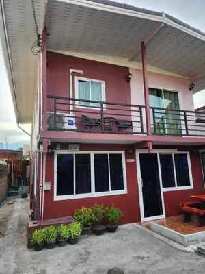 a red house with potted plants in front of it at Sabai - Sabai in Bangkok