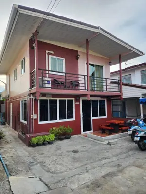 a red house with a balcony and a patio at Sabai - Sabai in Bangkok