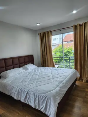 a bedroom with a large bed with a window at Sabai - Sabai in Bangkok
