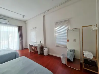 a hotel room with two beds and a mirror at Wanglang Home in Bangkok Noi