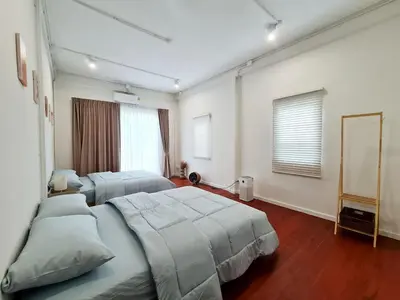 a bedroom with two beds and a mirror at Wanglang Home in Bangkok Noi