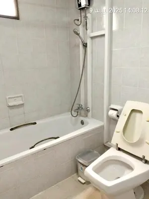 a bathroom with a toilet and a bath tub with a shower at Baan Arthit in Bangkok
