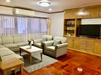 a living room with a couch and a tv at Baan Arthit in Bangkok