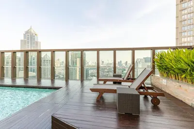 a balcony with a pool and a chair on a building at 2 BR in Downtown BTS Chitlom BKK in Bangkok