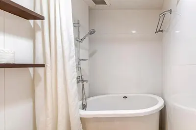 a white bathroom with a tub and a shower at 2 BR in Downtown BTS Chitlom BKK in Bangkok