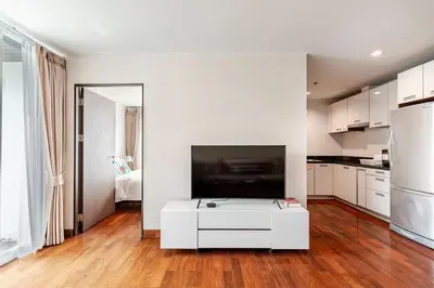 a white living room with a tv and a white coffee table at 2 BR in Downtown BTS Chitlom BKK in Bangkok