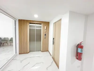 a room with a fire extinguisher on the wall at H-Banaat Hotel near Yanhee Hospital in Bangkok