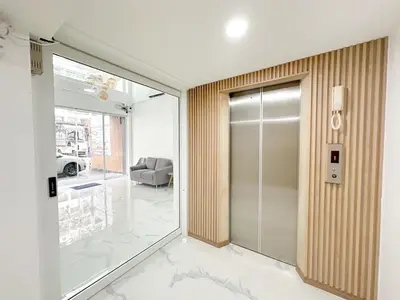 a hallway with a glass door and a living room at H-Banaat Hotel near Yanhee Hospital in Bangkok