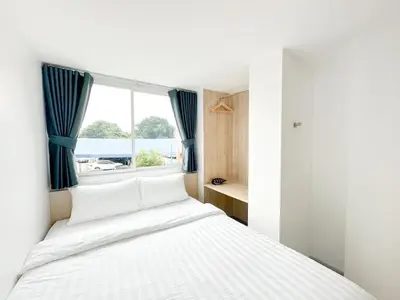 a bedroom with a large bed with a window at H-Banaat Hotel near Yanhee Hospital in Bangkok