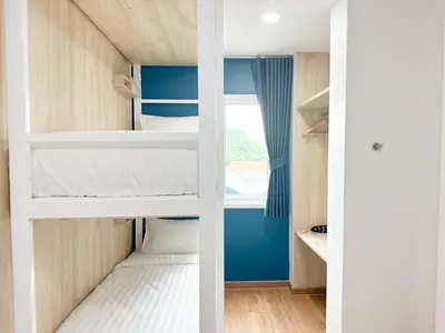 two bunk beds in a small room with a window at H-Banaat Hotel near Yanhee Hospital in Bangkok
