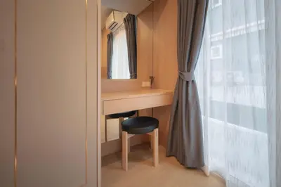 a room with a desk with a chair and a mirror at SiS at Sathorn St Louis in Bangkok