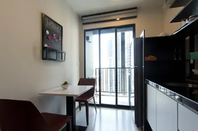 a small kitchen with a table and a balcony at BRAND New Sukhumvit Condo Cozy BTS in Bangkok