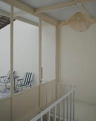 a room with a balcony with chairs and a table at Charming 3BR Design Loft in the Heart of Ari in Sathani Bang Su