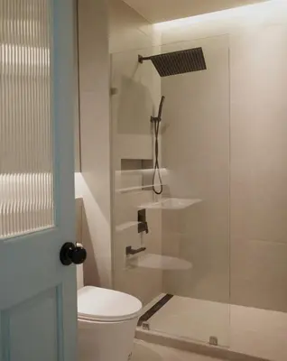 a bathroom with a toilet and a glass shower at Charming 3BR Design Loft in the Heart of Ari in Sathani Bang Su