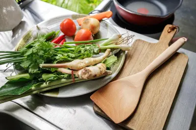 a plate of vegetables on a table with a cutting board at Baan Apak in Godown