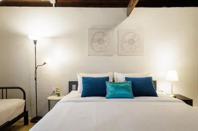 a bedroom with a large bed with blue pillows at Baan Apak in Godown