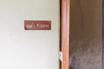 a sign on a wall next to a door at Baan Apak in Godown