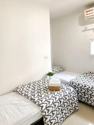 two beds in a room with white walls at 1sabai in Bangkok