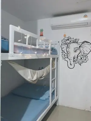 a bunk bed in a room with a drawing on the wall at 1sabai in Bangkok