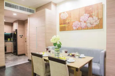 a dining room with a wooden table with chairs at Qiss Residence by Bliston in Bangkok