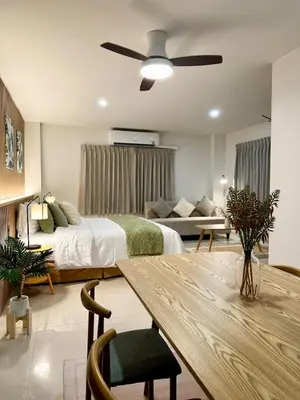 a bedroom with a bed and a couch and a table at Serene Escape 2 mins from SRT Wat Samien Nari in Bangkok