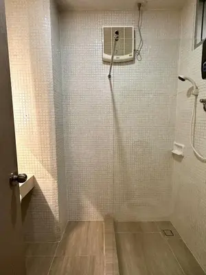a bathroom with a shower with a fan on the wall at Serene Escape 2 mins from SRT Wat Samien Nari in Bangkok