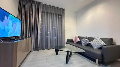 a living room with a couch and a glass table at Beautiful condo, BTS Thonglor, 5mins by walking in Bangkok