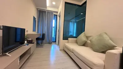 a living room with a white couch and a flat screen tv at Lovely Condo-BTS Thong Lo 5mins in Bangkok