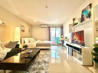 a large living room with a couch and a tv at Cosy Studio near BTS in Bangkok