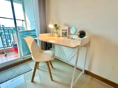 a desk with a chair in a room with a window at Cosy Studio near BTS in Bangkok