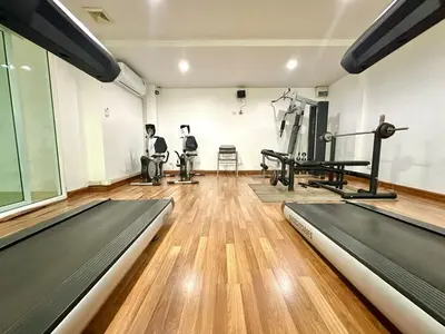 a gym with two treadmills and machines in a room at Cosy Studio near BTS in Bangkok
