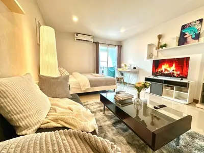 a living room with a couch and a fireplace at Cosy Studio near BTS in Bangkok