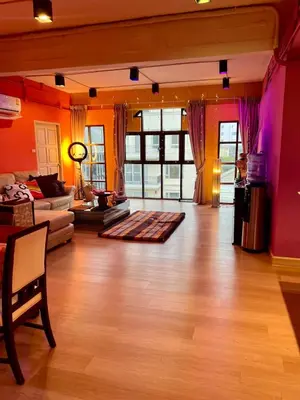 a living room with a couch and a table at Fab Rainbow Studio in Bangkok