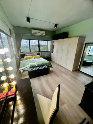 a bedroom with a bed and a living room at Fab Rainbow Studio in Bangkok
