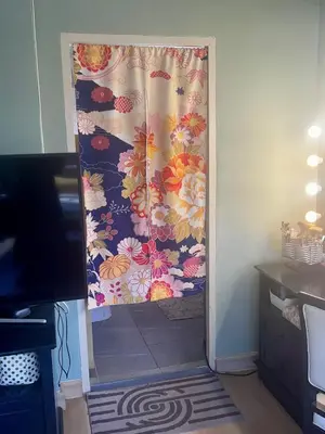 a door with a flowered shower curtain in a room at Fab Rainbow Studio in Bangkok