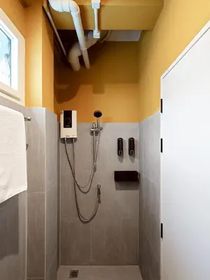 a bathroom with a shower with a hose at Au Luna Bangkok Hostel in Bangkok