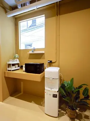 a kitchen with a small refrigerator and a window at Au Luna Bangkok Hostel in Bangkok