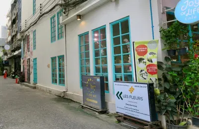 a store with a sign on the side of a building at Les Fleurs Bangkok Hostel in Bangkok