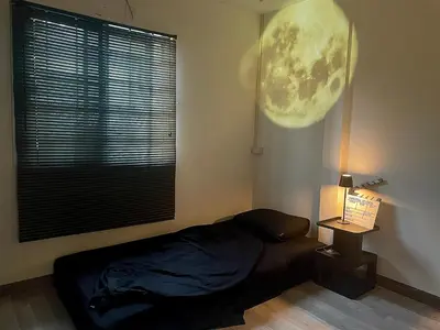 a bedroom with a bed and a large window at Tktattoo63 in Tha Akatsayan Don Muang