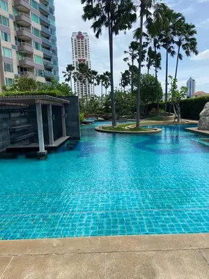 a blue swimming pool with palm trees and buildings at Room near Iconsiam 2km in Bangkok