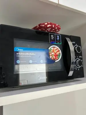 a microwave on a shelf with a bowl of food at 1BR Free pool&gym fast WIFI Airport Link in Sathani Ban Hua Mak