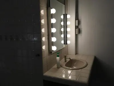 a bathroom with a sink and a mirror with lights at 42 Guest House in Bangkok