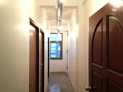 an empty hallway with a door and a window at 42 Guest House in Bangkok