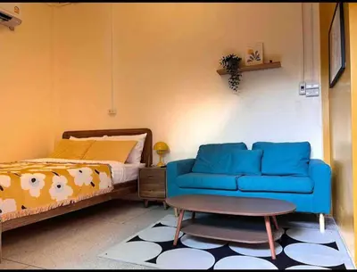a bedroom with a blue couch and a bed at Papaya House Bangkok - Wat Arun in Bangkok Noi