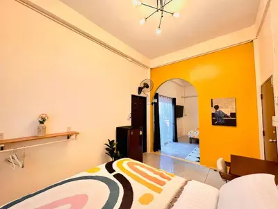 a bedroom with a bed and a yellow wall at Papaya House Bangkok - Wat Arun in Bangkok Noi