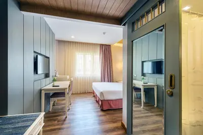a hotel room with a bed and a desk at Royal Rattanakosin Hotel - Near Grand Palace & Khaosan Road in Bangkok