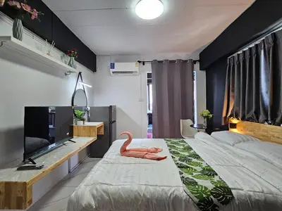 a bedroom with a large bed and a television at Irich Residence Theparak S407 Bts-Chang Erawan 2kms in Ban Khlong Hua Sakae