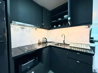 a kitchen with black cabinets and a sink at Civic Park in Bangkok