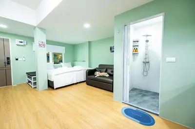 a living room with a bed and a glass door at GL Sport Club Serviced Residence in Bangkok